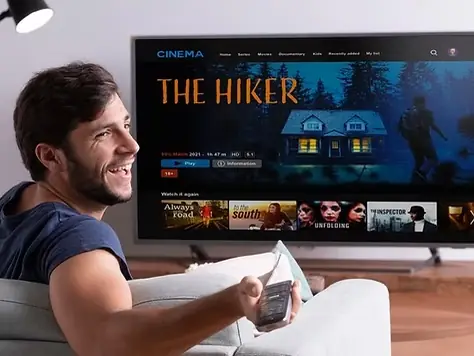 Homem assistindo televisão com controle remoto