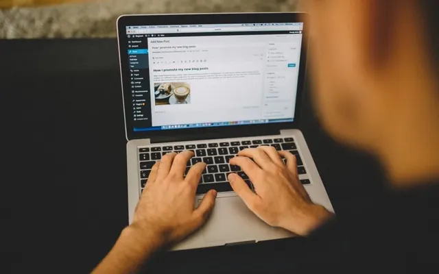 Mãos com notebook e computador no escritório