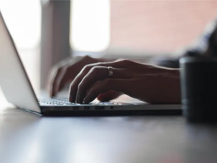 Mãos com notebook e teclado no escritório