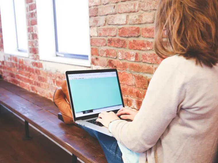 Mulher com notebook e computador no escritório